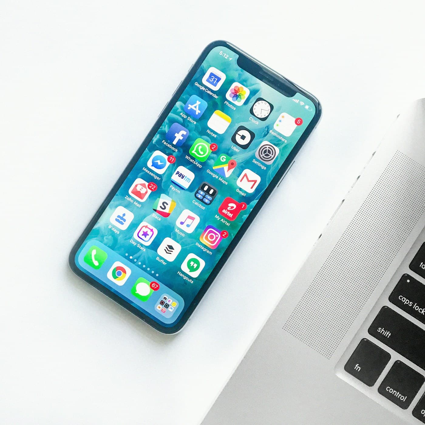 Mobile phone showing global communication apps beside a laptop